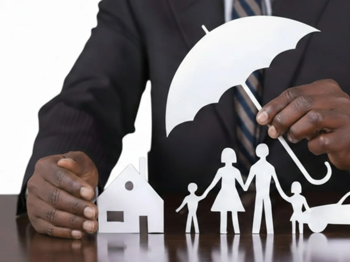 Advisor holding a protective umbrella over a cut-out family, home and car